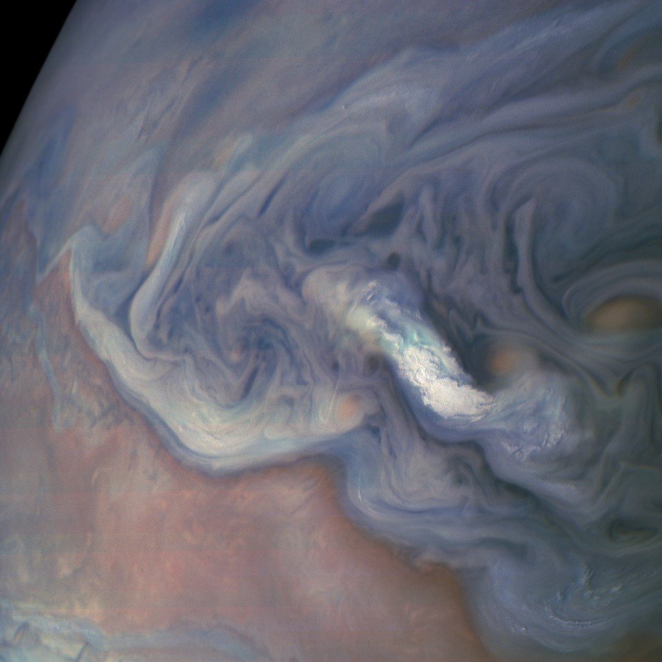 Close-up view of the cloudtops of a large, turbulent storm system on Jupiter's northern hemisphere.