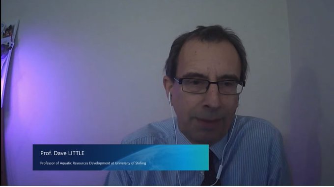 David Little sits in front of pale background. The box underneath says his name and 'professor of aquatic resources development at the University of Stirling'.