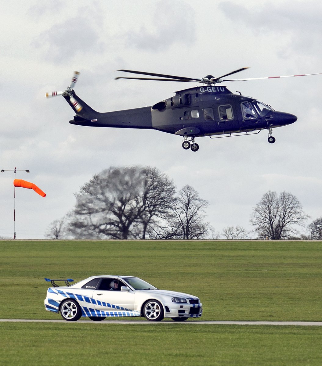GreySnapper03's tweet photo. A movie car experience day at Sywell Airport is added to by a helicopter hovering above. https://t.co/aDIEmoQdIC