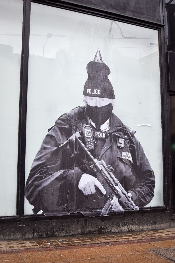 A huge mural showing the Bojo dressed as a policeman wearing a party hat has caught the eye of shoppers in Manchester. It is the work of 'Foka Wolf', an anonymous street artist. #JohnsonOut