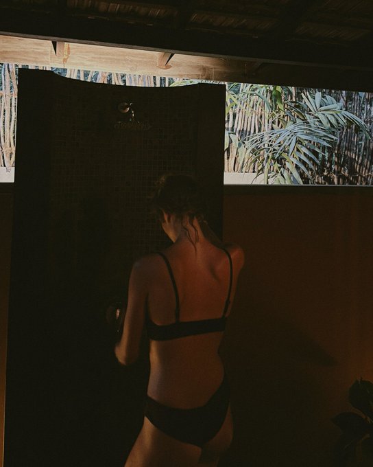 Tropical humid heat clinging to your skin, sunset dip in a small cove surrounded by palm trees, ocean