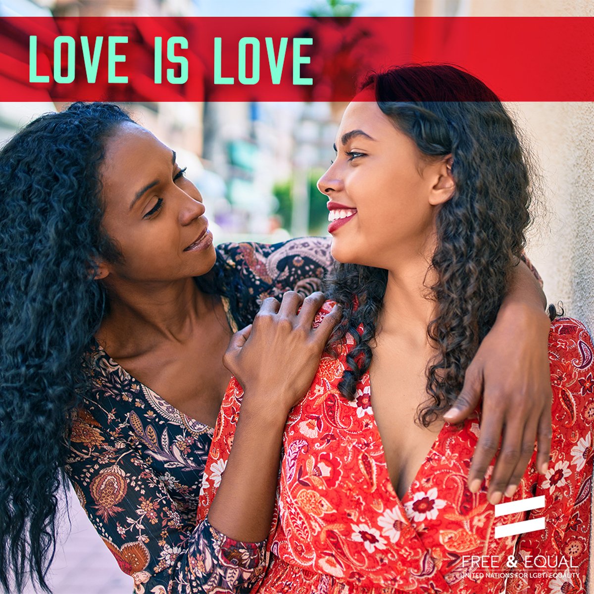 Two feminine presenting people are lovingly staring into each other’s eyes and smiling; the text on the image reads “Love is love”