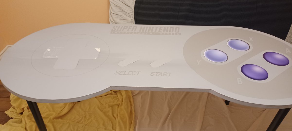CollectNintendo's tweet photo. SNES table was done. I was putting on the coats to seal it and the D-Pad ran causing the grey streak across the table (I was recommended the wrong finishing product). Ugh. Time to sand, repaint, and get the right polyurethane finish. #snes #nintendo #snesk https://t.co/aGFhc4KG2G