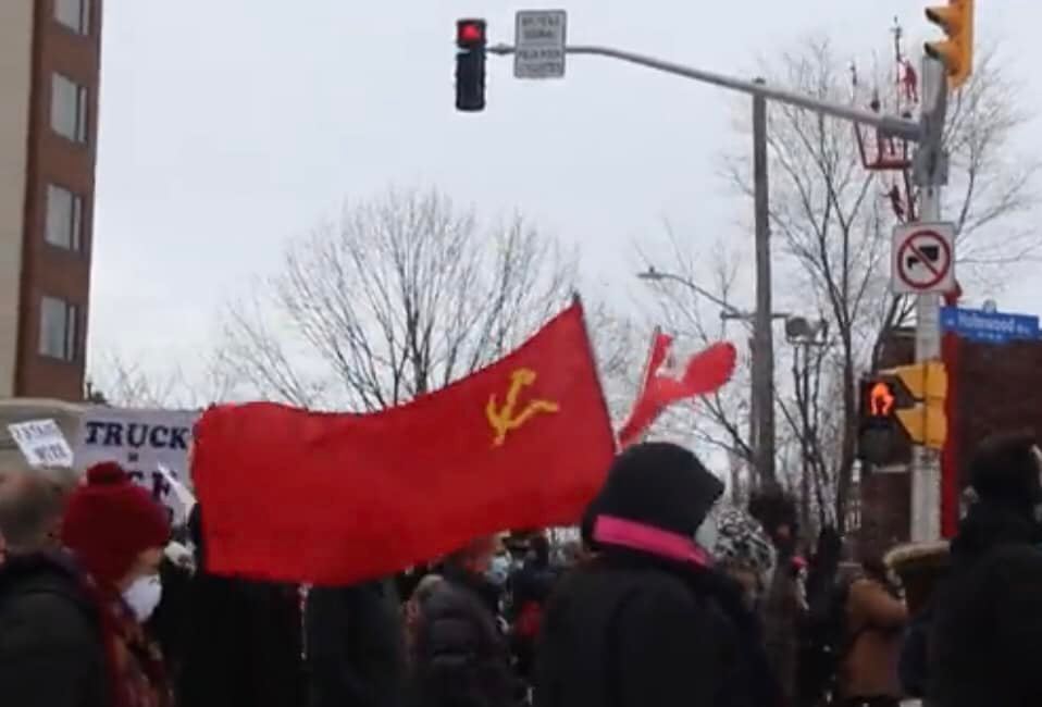 bcbluecon's tweet photo. The Hammer and Sickle flag proudly flown in the middle of the crowd of counter-protesting federal employee union PSAC members in Ottawa. https://t.co/AX99vKa09H