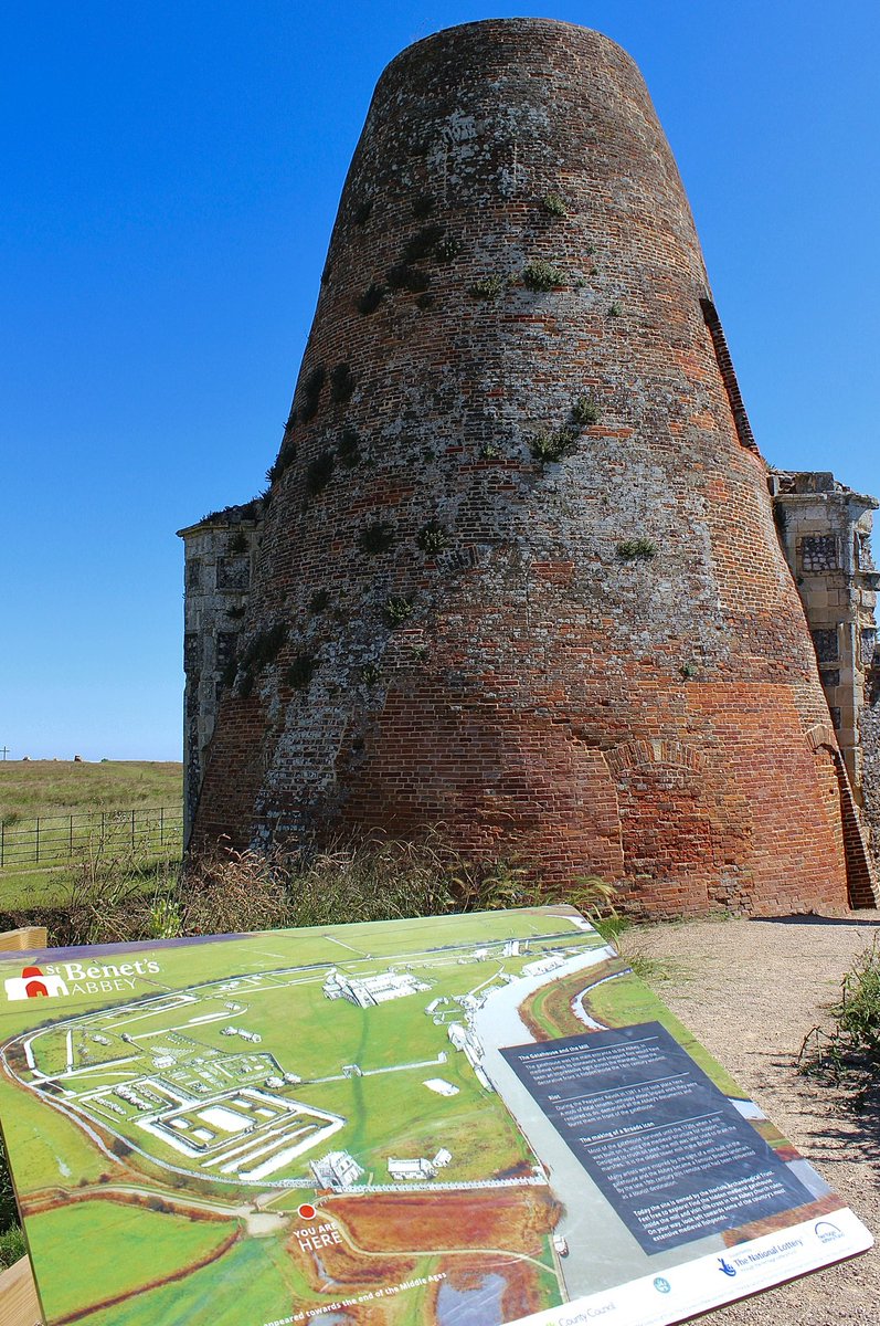 The gatehouse of St Benet’s Abbey as it looks today embedded in the structure of the 18th windmill. My reconstruction is shown as a ghost image over a birds eye view photograph of the whole site on the on-site panel. #MonumentMonday #Norfolk