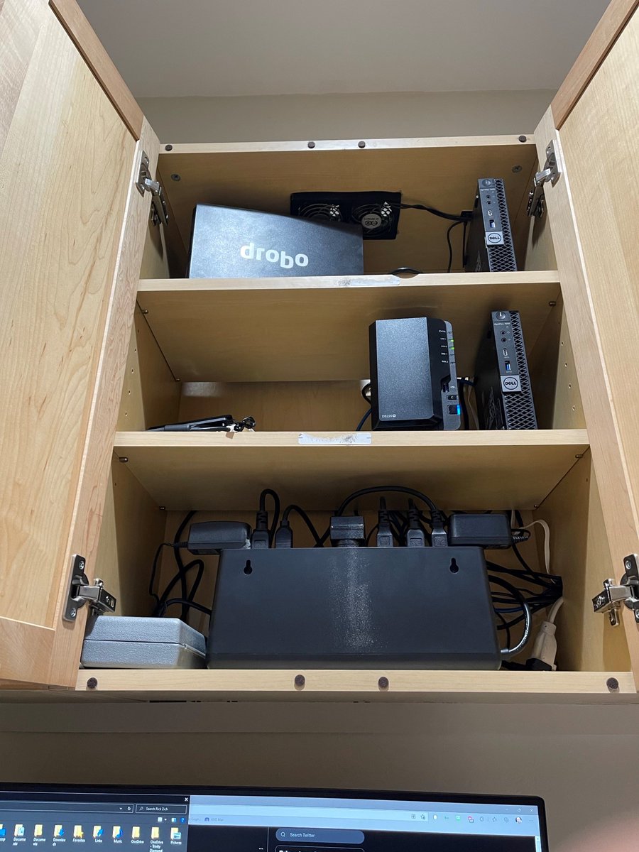 RickZich's tweet photo. @CohhCarnage Immediately above my monitors I put in overhead cabinets from Home Depot and I put in nearly silent usb fans in a top cutout. It is holding a Drobo NAS, 2 mini Dell computers, UPS, and Synology NAS. DBs went from 57 down to 38. Might try that https://t.co/PZ8IQ8ZGqY