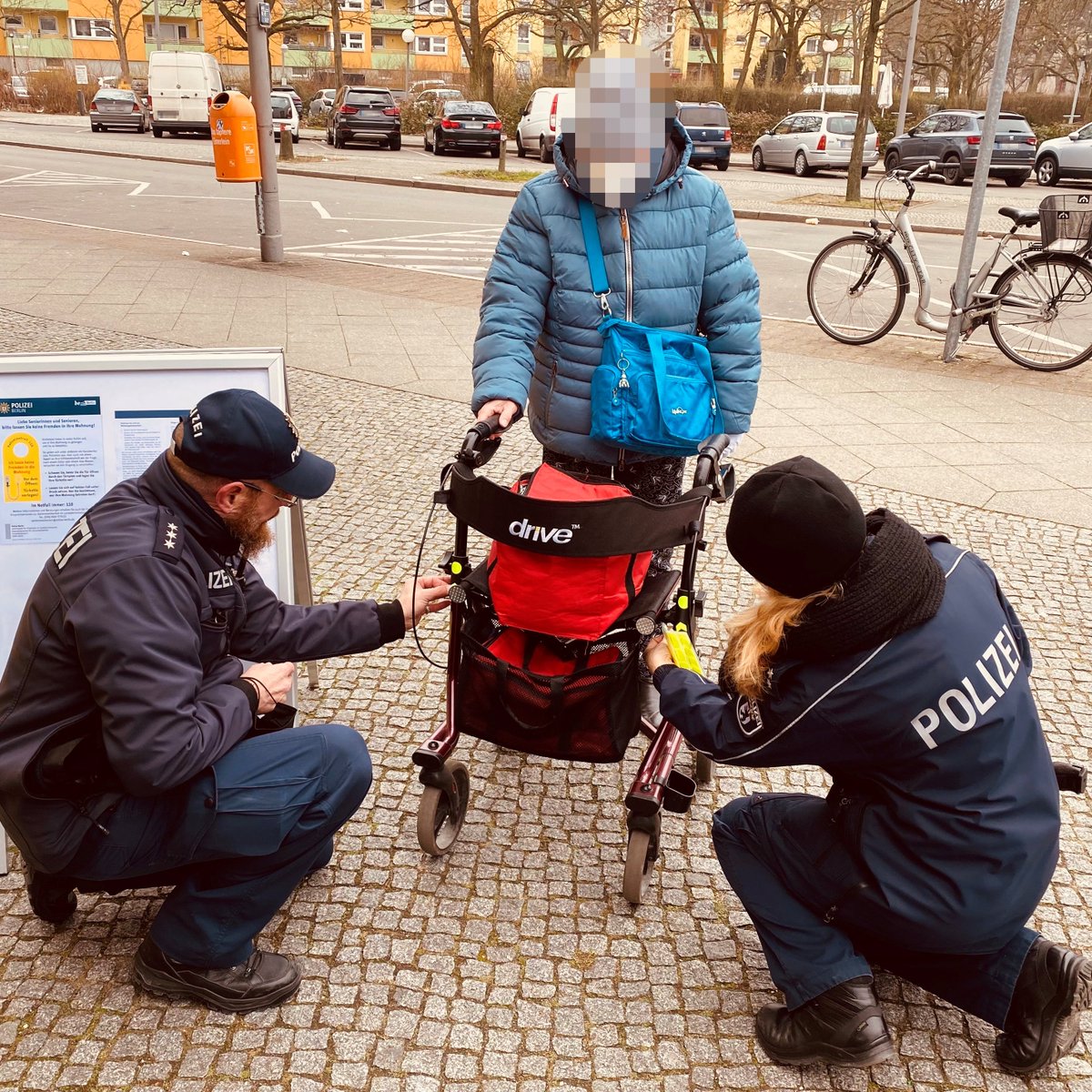 Polizisten bringen Reflektoren an einem Rollator an.
