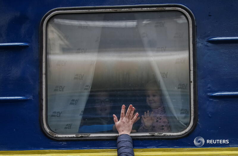 Children look out from an evacuation train to Lviv as they say goodbye to their father at Kyiv central train station in Ukraine reut.rs/3MjUxjN 📷 Gleb Garanich