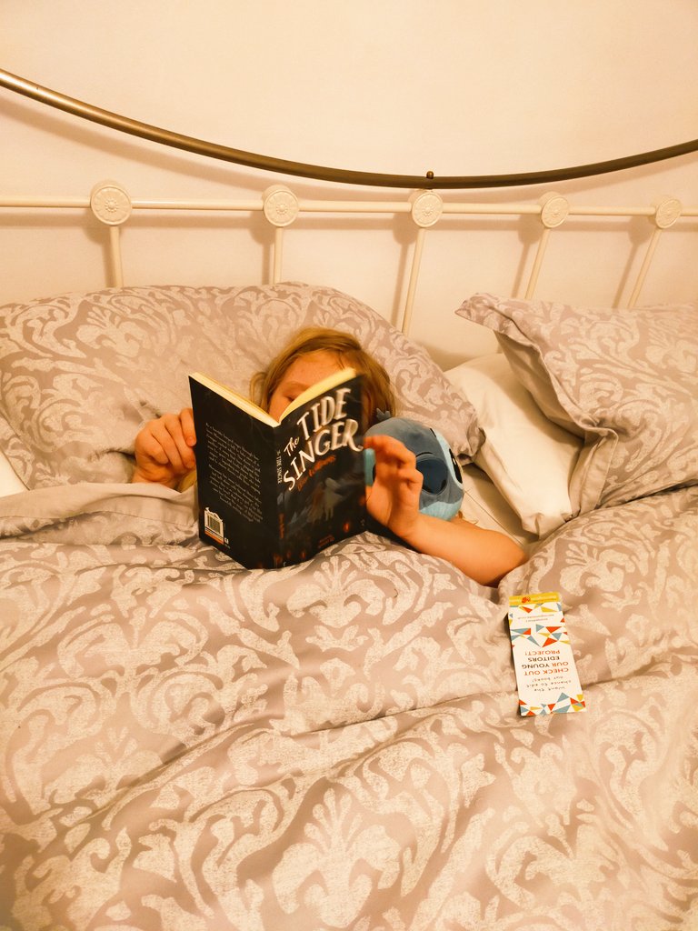 Ms_M_Israel's tweet photo. One very eager little girl ready to start reading her signed copy of The Tide Singer. Thank you to Tonyrefail Community School's Author in Residence @Eloisejwilliams . @TonyrefailCS #thetidesinger https://t.co/xvpFEKtkfo