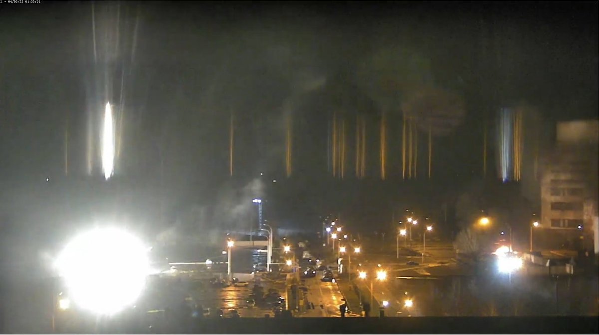 sentdefender's tweet photo. Heavy Fighting is occurring at the Zaporizhzhya Nuclear Power Plant in the city of Enerhodar, on the Livestream right in front of the Plant you can see a Russian Armored Column that is under fire from Ukrainian Defensive Forces and multiple vehicles appear to have been struck. https://t.co/coDES6dVsj
