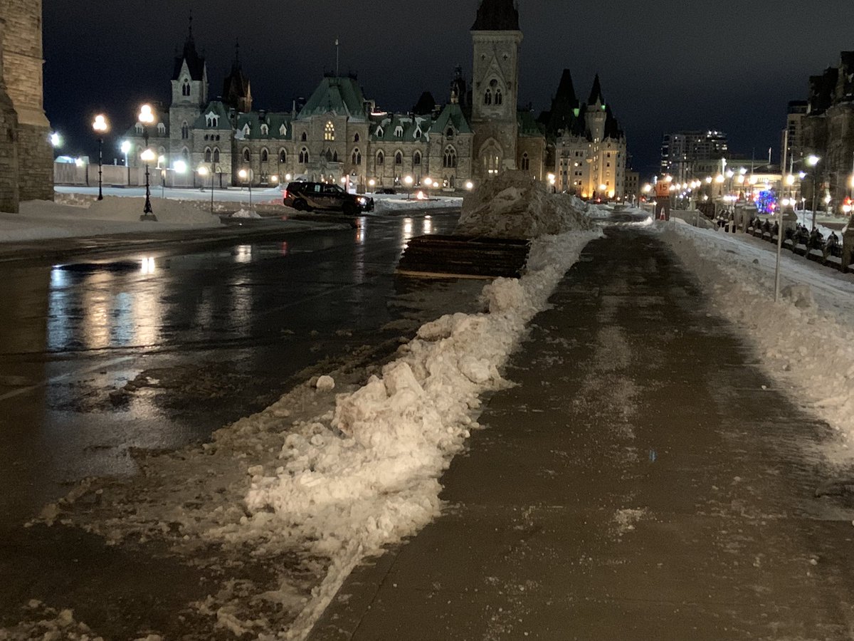 CBCRaffy's tweet photo. The quiet in front of Parliament Hill inside the secure zone tonight--fences dismantled, a lone protest sign left in a snowbank. #protestconvoy #cdnpoli https://t.co/uZv6tQz4Kt