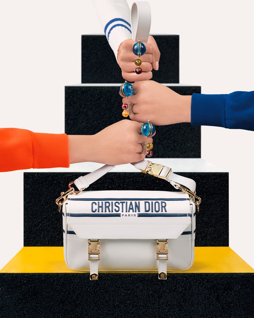 Dior's tweet photo. Playful Plexiglas rings capturing the joy of Anna Paparatti's artworks and a pared-down 'Diorcamp' bag are just some of the pieces that distill the sixties inspirations of #DiorSS22 by Maria Grazia Chiuri https://t.co/wq1qDVJZFZ in the campaign shot by Brigitte Niedermair. https://t.co/v2OyDttPNm