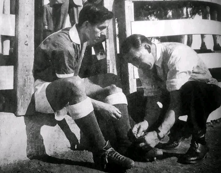 DespliegueFutCL's tweet photo. El día del debut en el fútbol profesional de Leonel Sánchez, en la foto junto a su padre Juan Sánchez (Campeón Nacional de boxeo peso gallo) amarrando los zapatos de su hijo para su estreno en la Universidad de Chile. Un 13 de septiembre de 1953. FOTÓN 🇨🇱⚽. https://t.co/hbZYXQpnms