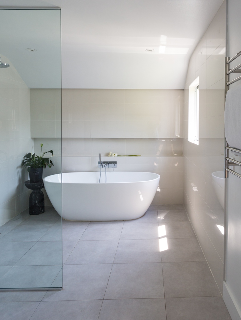 The freestanding tub and shower combo make a dynamic statement in this master bathroom wet room. Read more about this modern upgrade project <a href="/dwellmagazine/">dwellmagazine</a>
