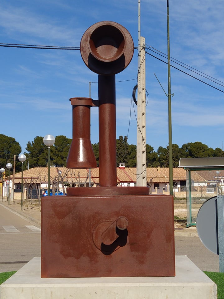 EscatronTurismo's tweet photo. La hemos conocido como la Plaza de Teléfonos, por estar allí la centralita telefónica. Hoy luce así de magnífica, con una espléndida escultura homenaje a lo que se conocía como como teléfono de vela o candelabro. Pasear por la parte del poblado de Escatrón tiene premios como éste https://t.co/rmy4sQ0oiD