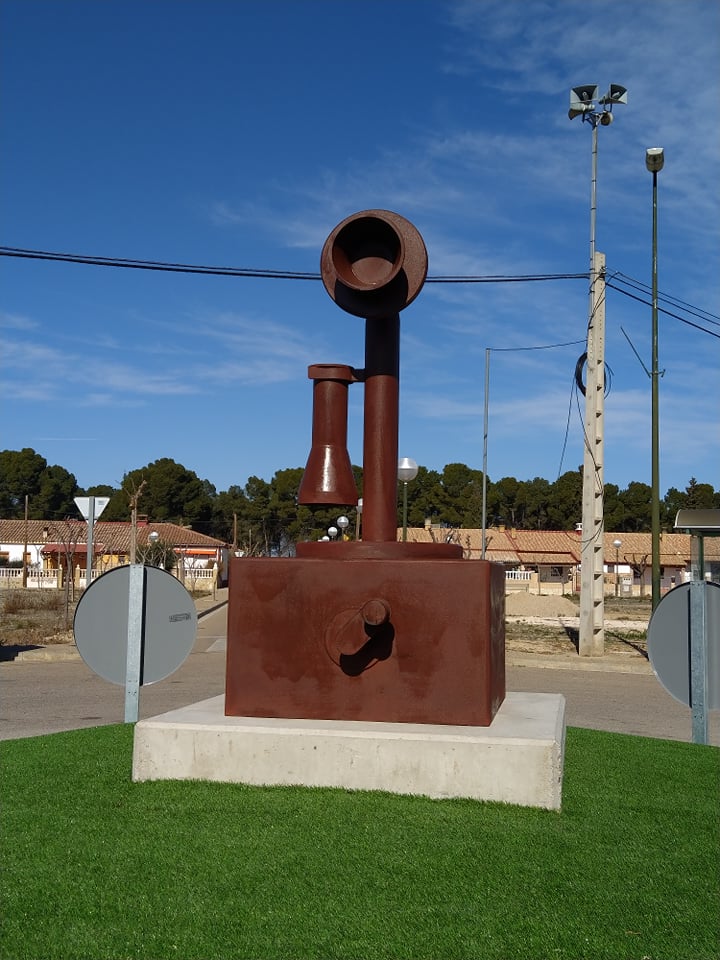 EscatronTurismo's tweet photo. La hemos conocido como la Plaza de Teléfonos, por estar allí la centralita telefónica. Hoy luce así de magnífica, con una espléndida escultura homenaje a lo que se conocía como como teléfono de vela o candelabro. Pasear por la parte del poblado de Escatrón tiene premios como éste https://t.co/rmy4sQ0oiD