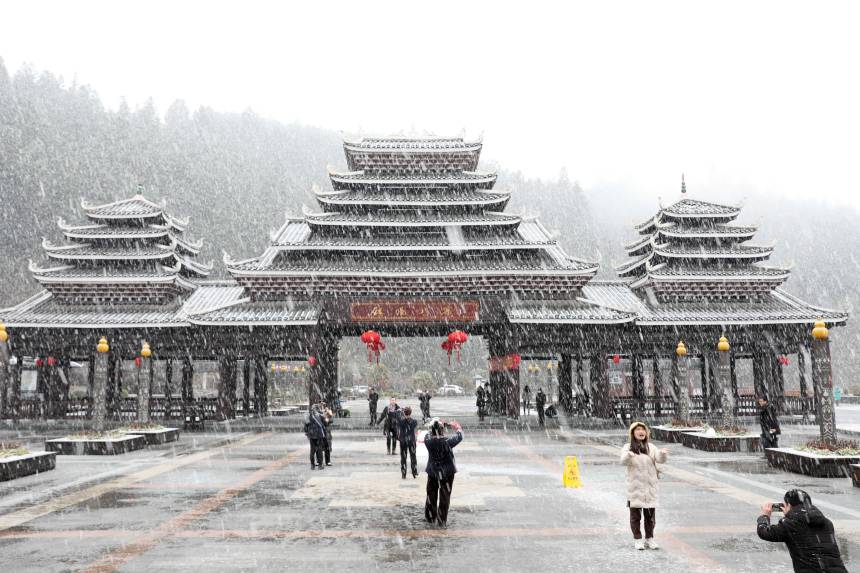 Snowflakes flutter down to touch the landmark buildings of Sanjiang Dong Autonomous County in south China's Guangxi, which include the Chengyang Fengyu Bridge, the Drum Tower and the Diaojiaolou building (houses on stilts) group.