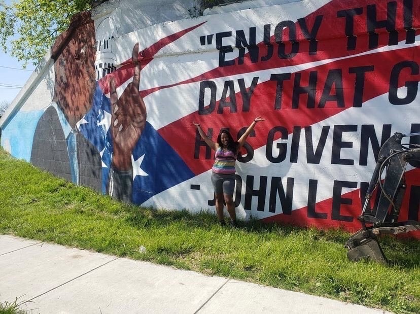 Upon meeting John Lewis' family and studying his history, Buffalo artist Princessa Williams chose this specific image and quote, "Enjoy this day that God has given us," because it spoke to her not only as an artist, but as a woman of color - which she is first.