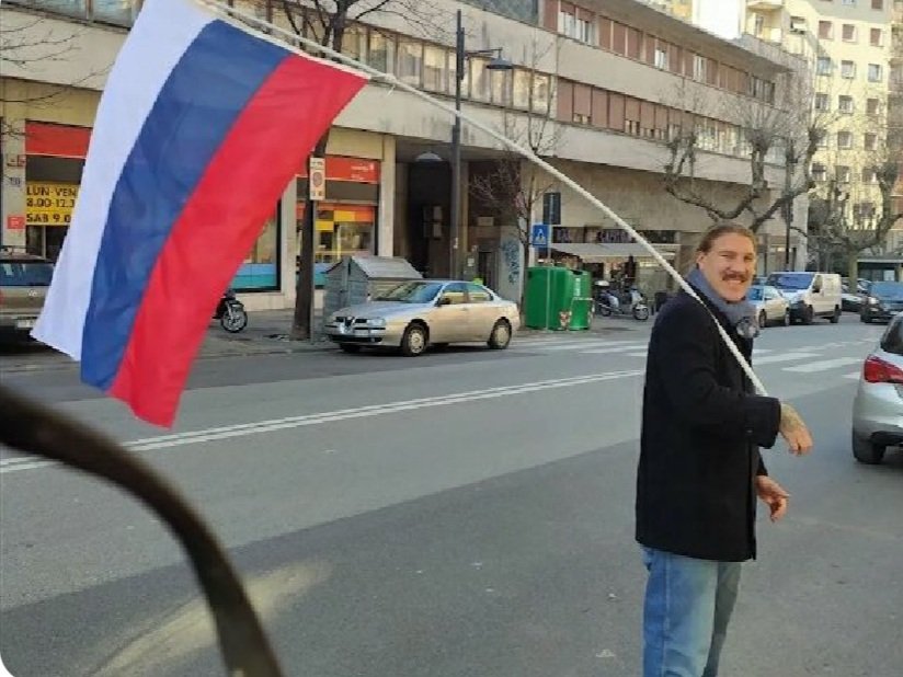 PBerizzi's tweet photo. Questo uomo che gira per Trieste con la bandiera di chi sta bombardando l' #Ucraina e con il rosario è l'ex cons. comunale fascista Fabio Tuiach, già Lega e FN, pugile, portuale, novax, no greenpass, fan di Hitler e di Putin, "crociato" e "patriota". Qui c'è tutto spiegato bene. https://t.co/Pc50yQGa8c