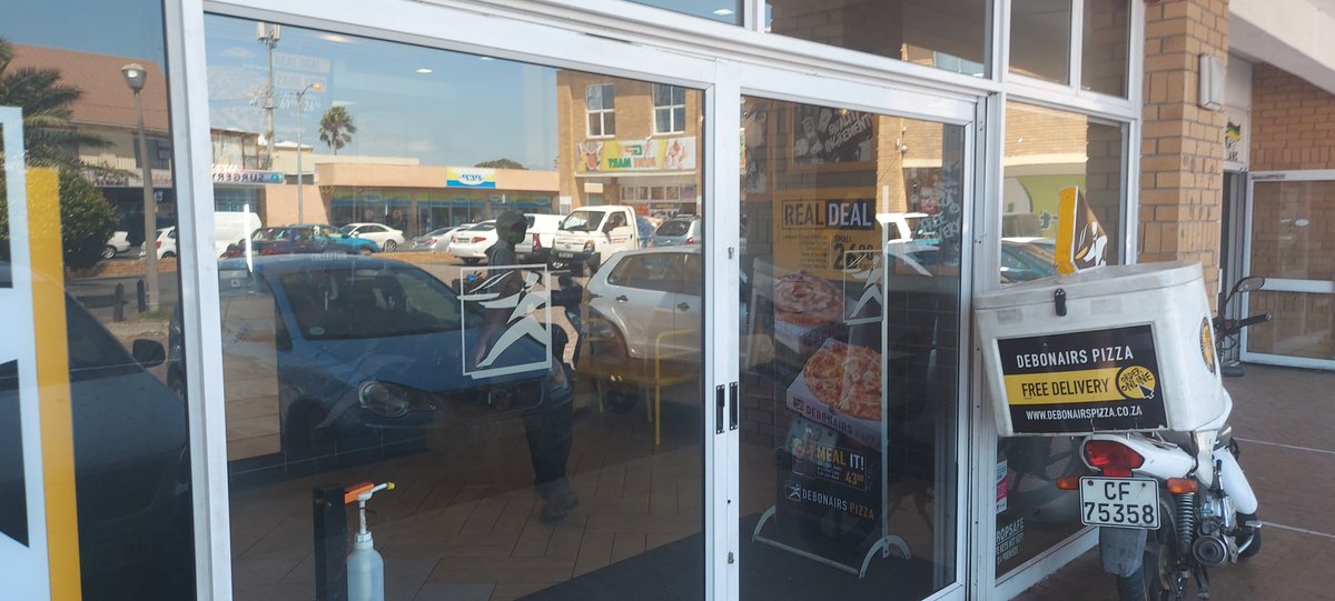 Mkan69's tweet photo. @DebonairsPizza Grassy Park is at it AGAIN with exceptional service. Times on the window indicate that they open at 10h00. I suggested they change  time indicated on the window and she abruptly says "No we don't have to change it. Everyone knows that we open at 13h00 on Mondays" https://t.co/Oz2gyjrKQ0