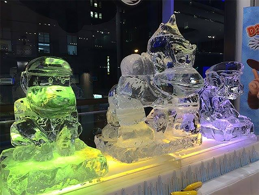Ice sculptures of Diddy, Donkey, and Dixie Kong at the Nintendo World Store in New York City. Fake bananas can be seen in the foreground and a Tropical Freeze sign with a Diddy render is visible to the right.