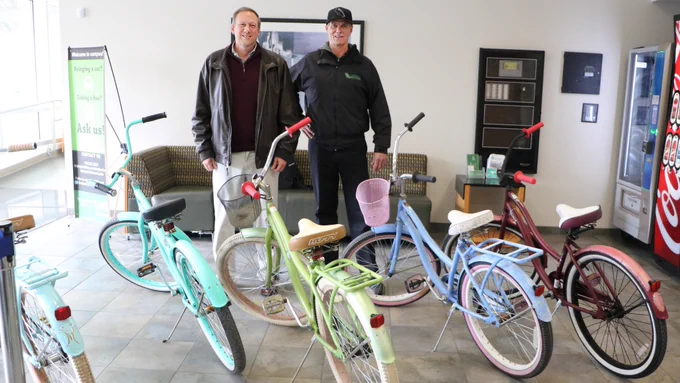 Senior Director Bill Donovan and Assistant Director Keith Kregel stand near the donated bikes.