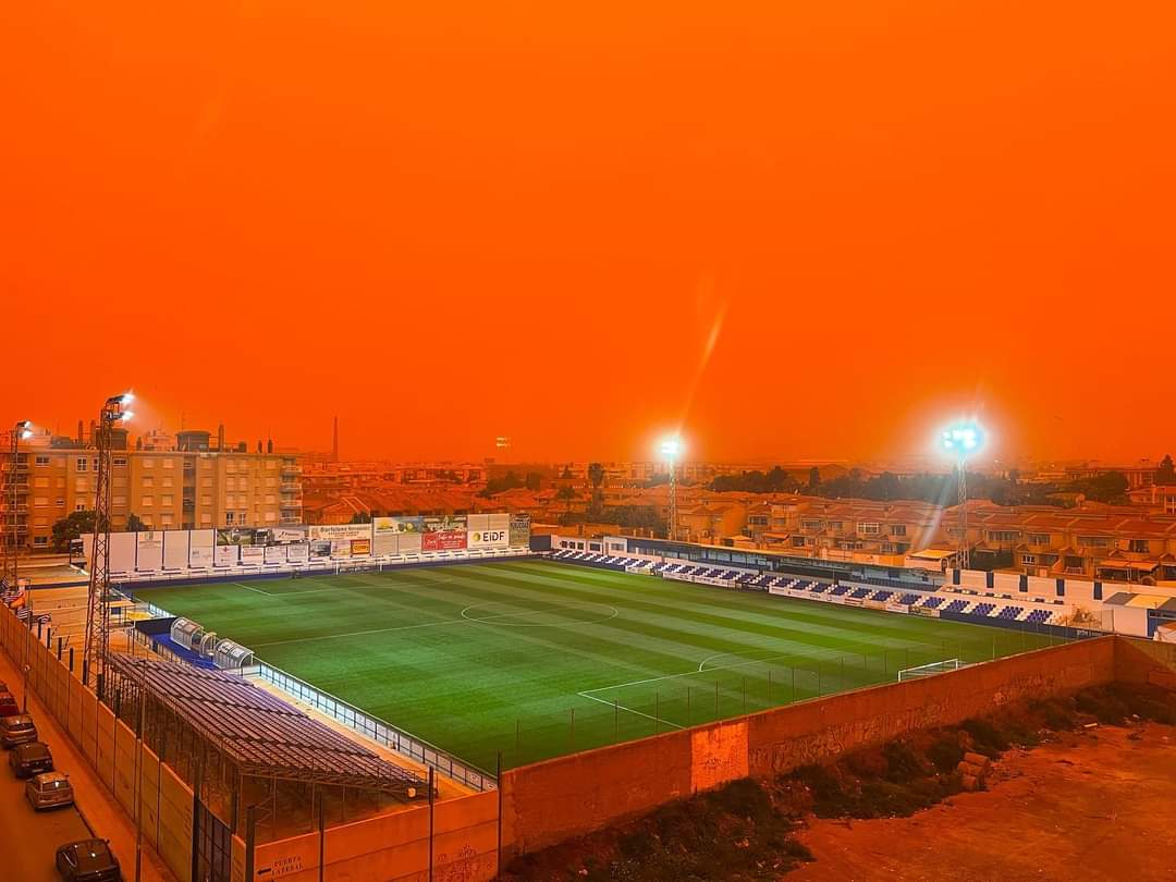 PacojoSER's tweet photo. Campo de futbol del Aguilas en Murcia con la calima. Cero filtros. Cielo pimentonero!!!!!  Via @MeteoChatSE https://t.co/v1fL4smxRC