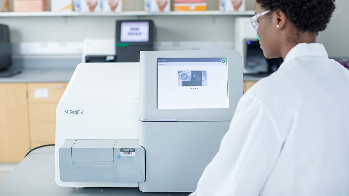 Scientist in a lab using an Illumina MiSeqDx sequencer.