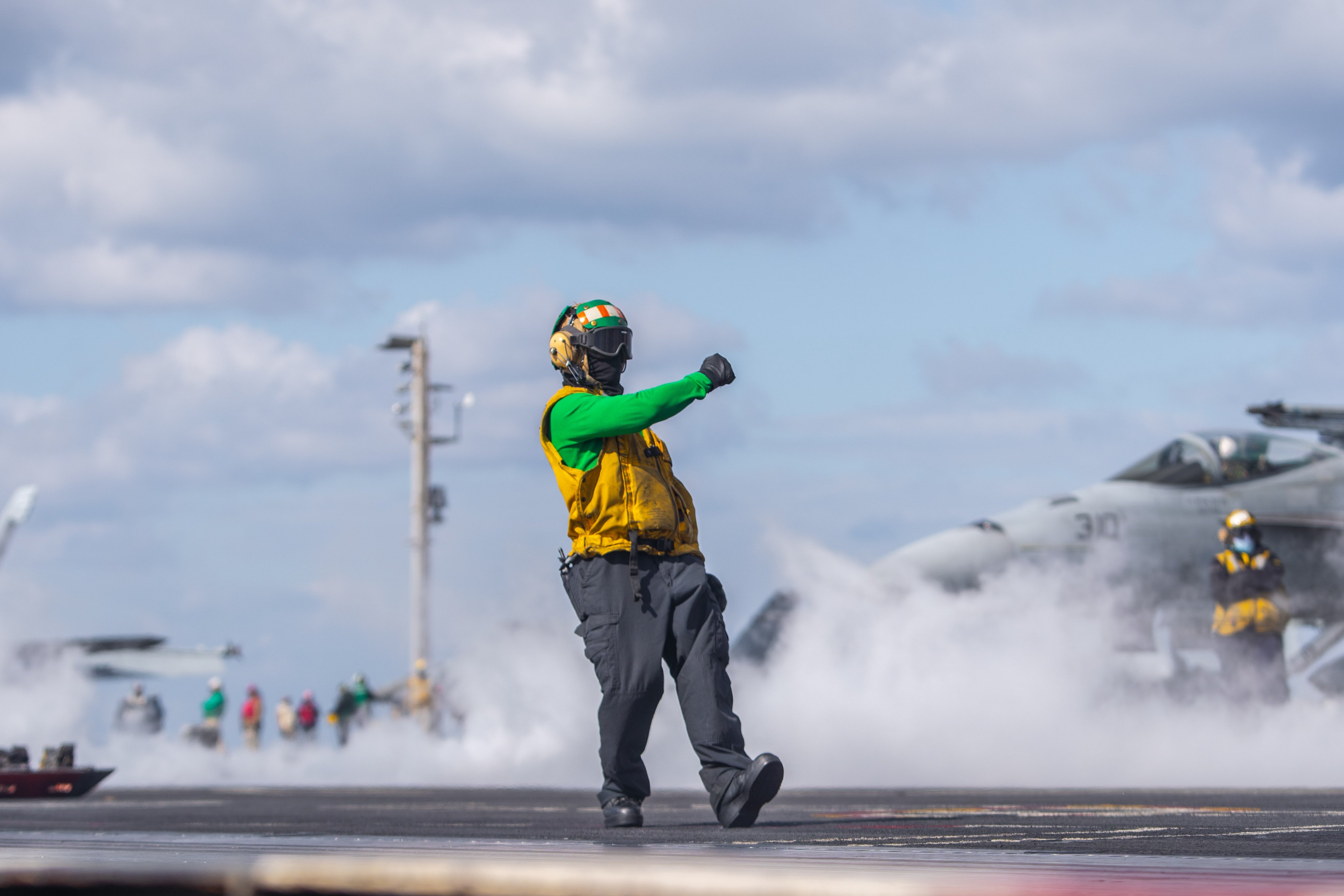 Aviation Boatswain's Mate (Equipment) 1st Class Troy-Phillip Obuga, from Morgan Town, West Virginia, signals a launch completion on the flight deck of the Nimitz-class aircraft carrier USS Harry S. Truman (CVN 75), Mar. 10, 2022. The Harry S. Truman Carrier Strike Group is on a scheduled deployment in the U.S. Sixth Fleet area of operations in support of U.S., allied and partner interests in Europe and Africa. (U.S. Navy photo by Airman Marvin Gabriel)