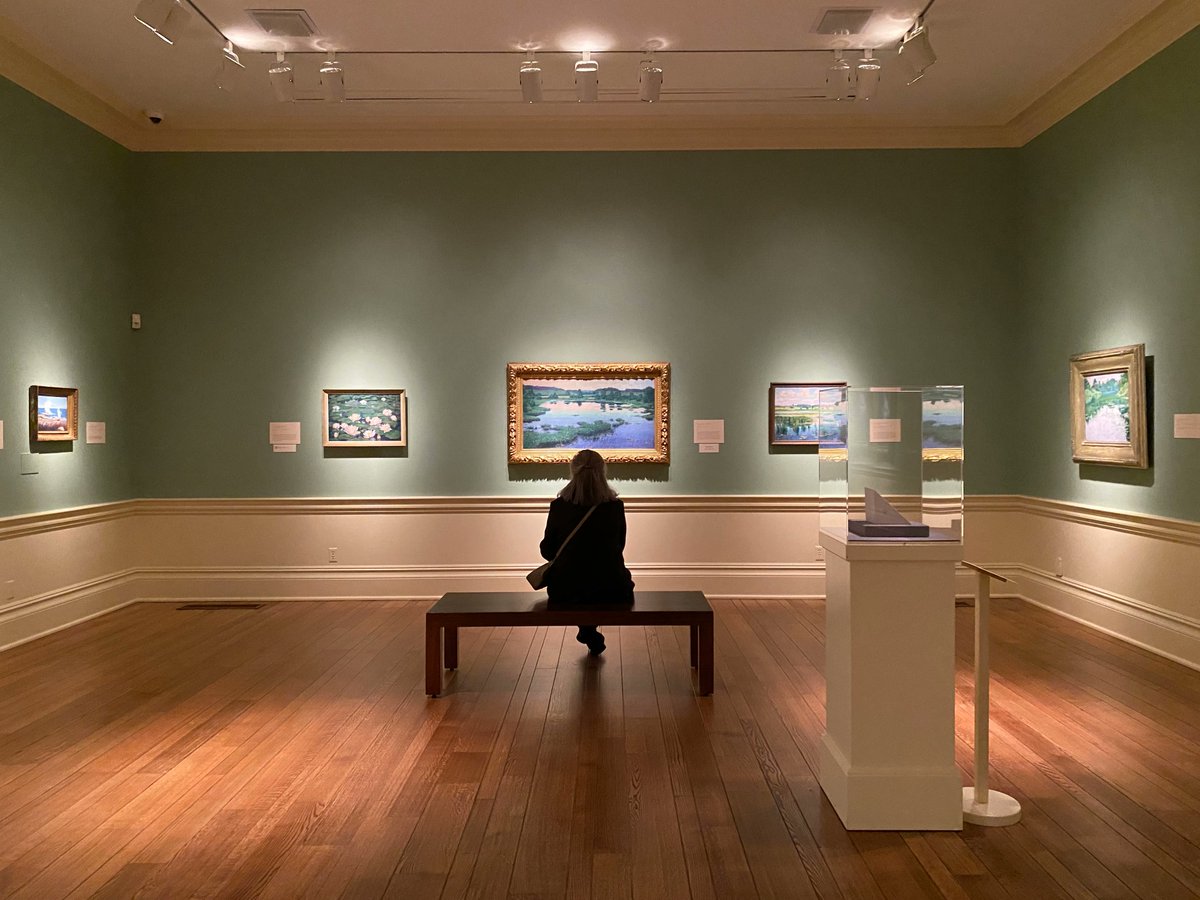 Find your ✨museum moment of zen✨ at the Dixon. 

Photo ID: woman sitting on a bench, looking at an impressionist landscape painting
