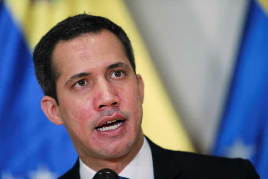 Juan Guaidó of Venezuela stands in front of a blue and yellow flag