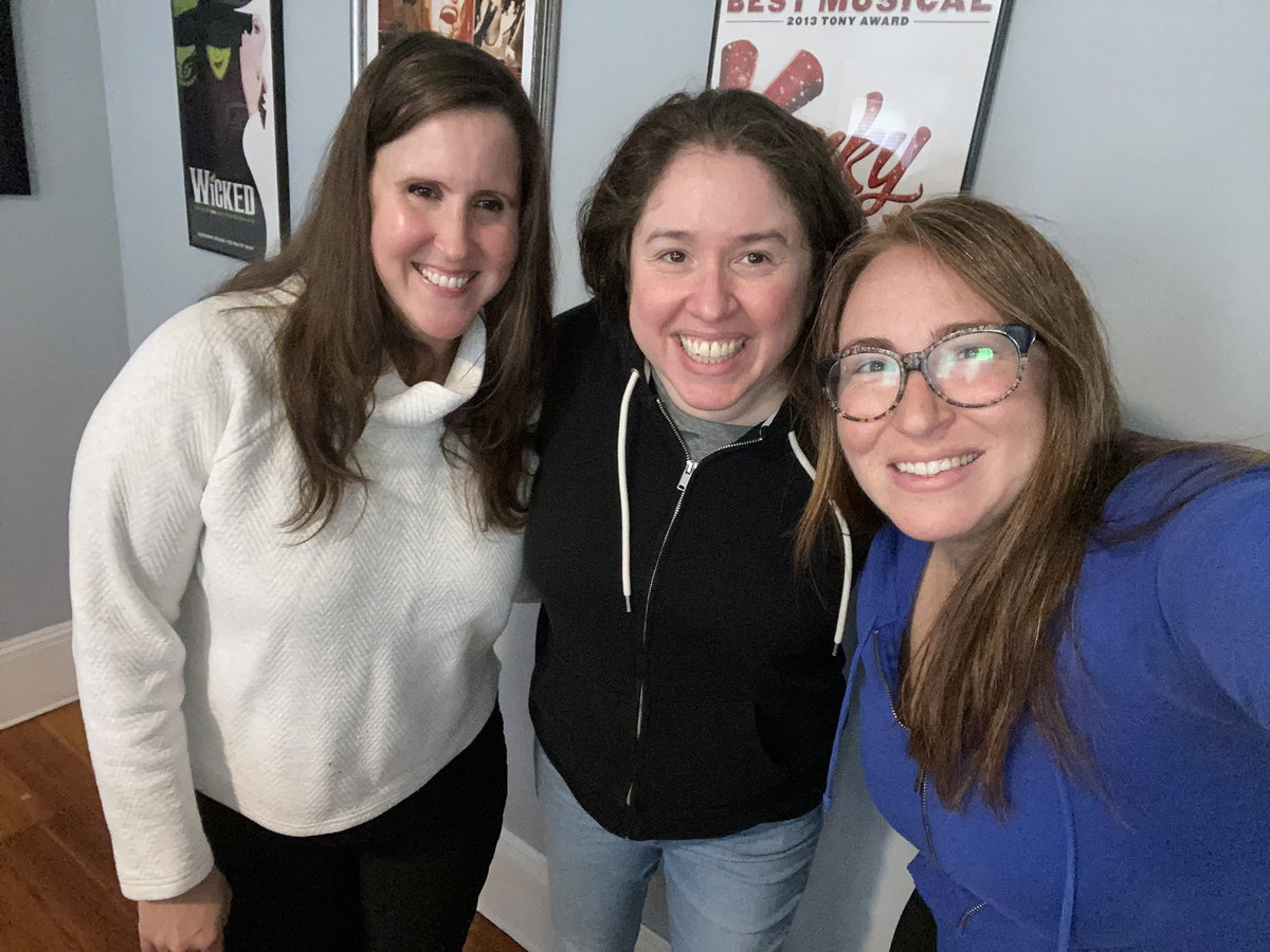 Kerry, Alice, and Jen smiling in front of framed Broadway musical posters.