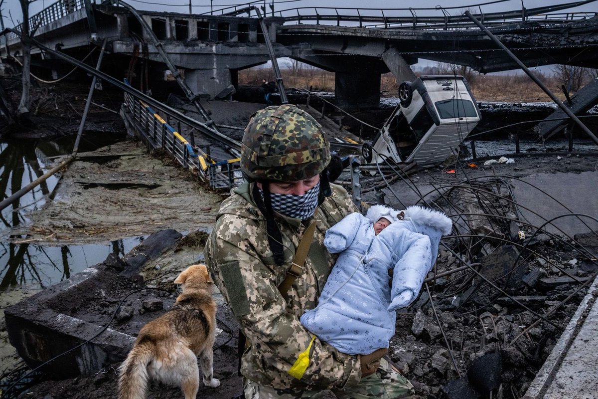 ukraineinternal's tweet photo. Ukrainian soldier carrying a baby through a destroyed bridge near Kyiv. Photo: CNN. #StandWithUkraine️ #StopPutinNOW https://t.co/TE8FbCFOEB