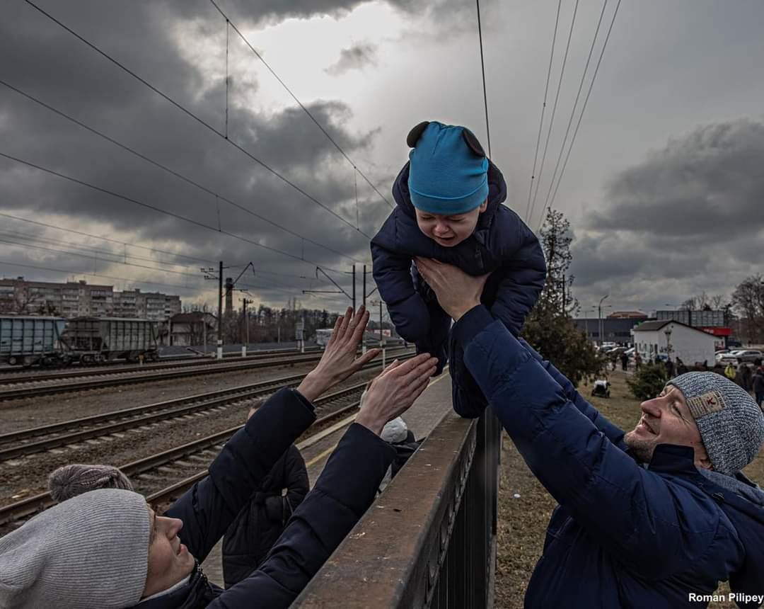 Hotmillenium's tweet image. #WAR

 In this powerful photo, a father who is remaining in Ukraine passes his son over a fence to his wife before the arrival of an evacuation train that will take the wife and the son to safety…