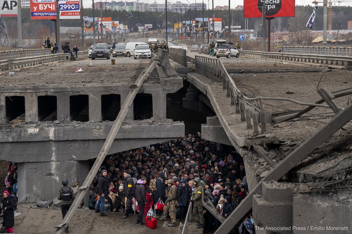 Ukrainians crowd under a destroyed bridge as they try to flee crossing the Irpin river in the outskirts of Kyiv, Ukraine, Saturday, March 5, 2022.