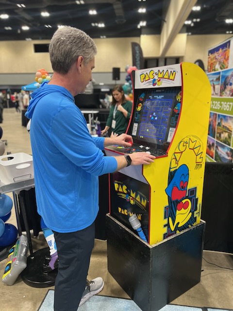 ArkBlueCross's tweet photo. Who got the highest score on Pac-Man at the Little Rock Marathon Expo? It may have been our President and CEO Curtis Barnett! Thanks to everyone who came by our booth. You made it legendary! #LRMarathon #LR262 #Legendary #BYFC2022 https://t.co/rKb19lLJCp