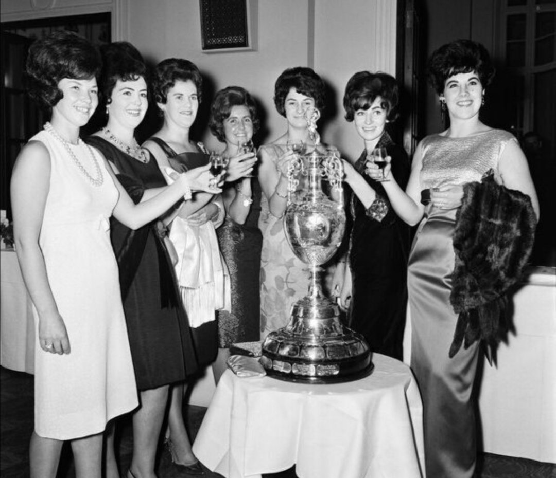 Wives of the players pose together next to the League Championship trophy.
L-R: Mrs Bette St John, Mrs Pat Hunt, Mrs Joyce Moran, Mrs Alma A Court, Mrs Edith Milne, Mrs Margaret Yeats and Mrs Carmel Stevenson.
28th September 1964