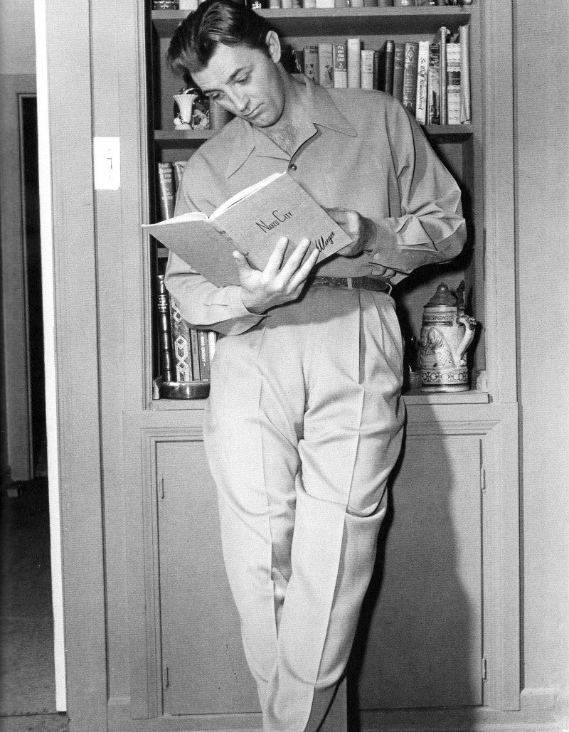Robert Mitchum reads a copy of Weegee’s The Naked City.