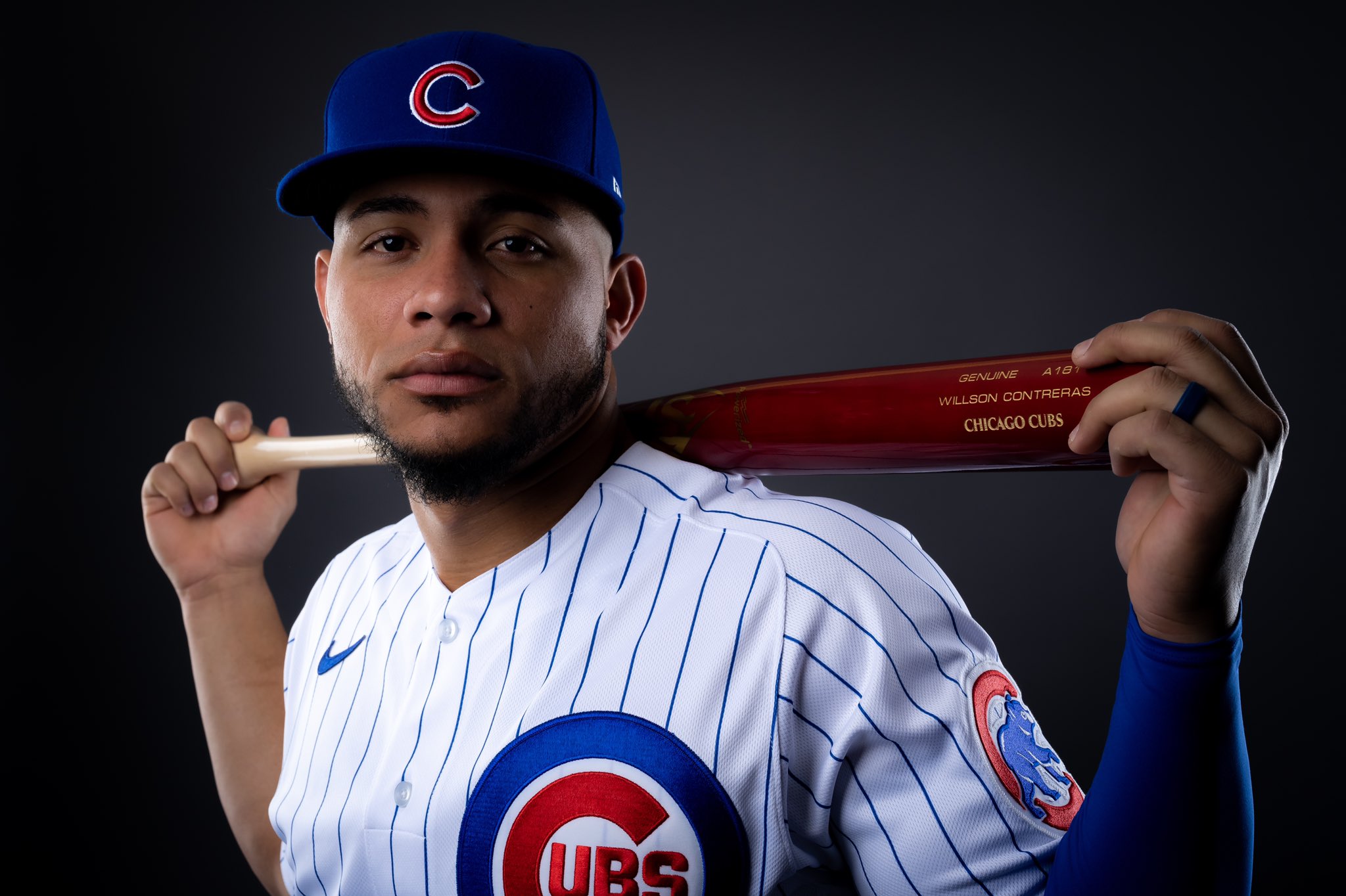 Willson Contreras poses holding a bat behind his shoulders.
