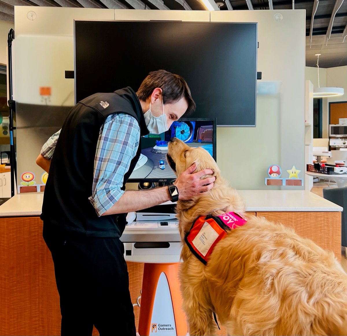 YNHH's tweet image. This week Yale New Haven Children&apos;s Hospital celebrates #TeenTechWeek. Max Williams, Child Life Gaming Specialist, enjoys some gaming time alongside his furry colleague Nana. Nana and Max would like to remind everyone to have fun and be safe online.