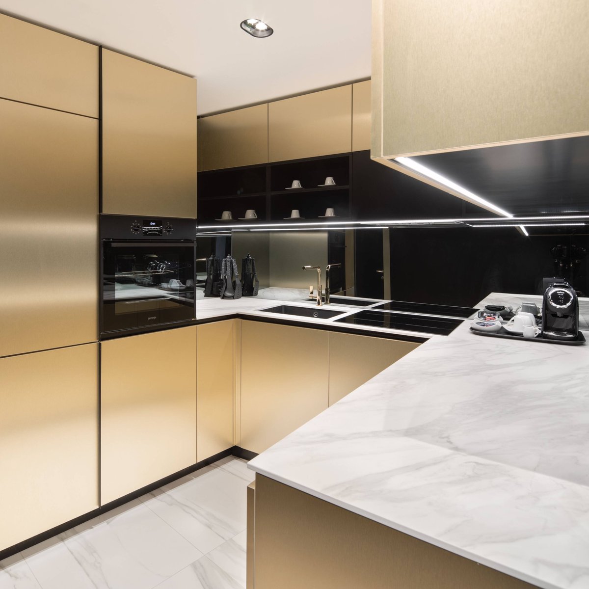 Kronospan's tweet photo. Elegant, rich, and perfectly designed, this kitchen has an excellent balance of black &amp; white, perfectly combined with the noble shine of #BrushedGold and the slim look of our #Venato #worktop.
Design and realization: Studio Geci 

#MadeWithKronospan #AvantGarde #KitchenDesign https://t.co/6I4WDnpnis