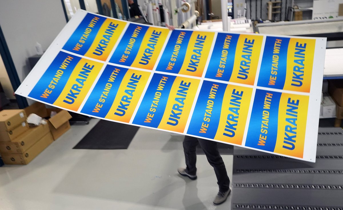 Worker John Aubuchon walks a sheet of newly printed Ukraine yard signs over to a cutting machine at the Fast Sign store in Maryland Heights, Missouri on Wednesday, March 9, 2022. The printing shop is making the signs to raise funds for the war torn country. Photo by Bill