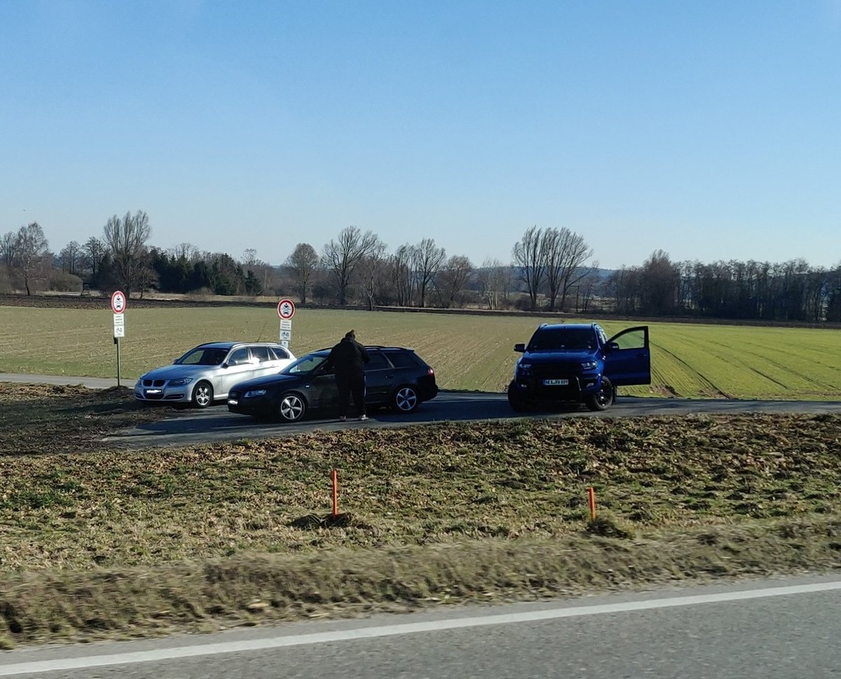 Laut Schildern dürfen BWM und Audi die Straße nicht weiter nach links befahren. Den Weg zur Straße rechts blockiert Rainer und verhindert so, das sie weiterfahren können. 
Das ist Nötigung oder?