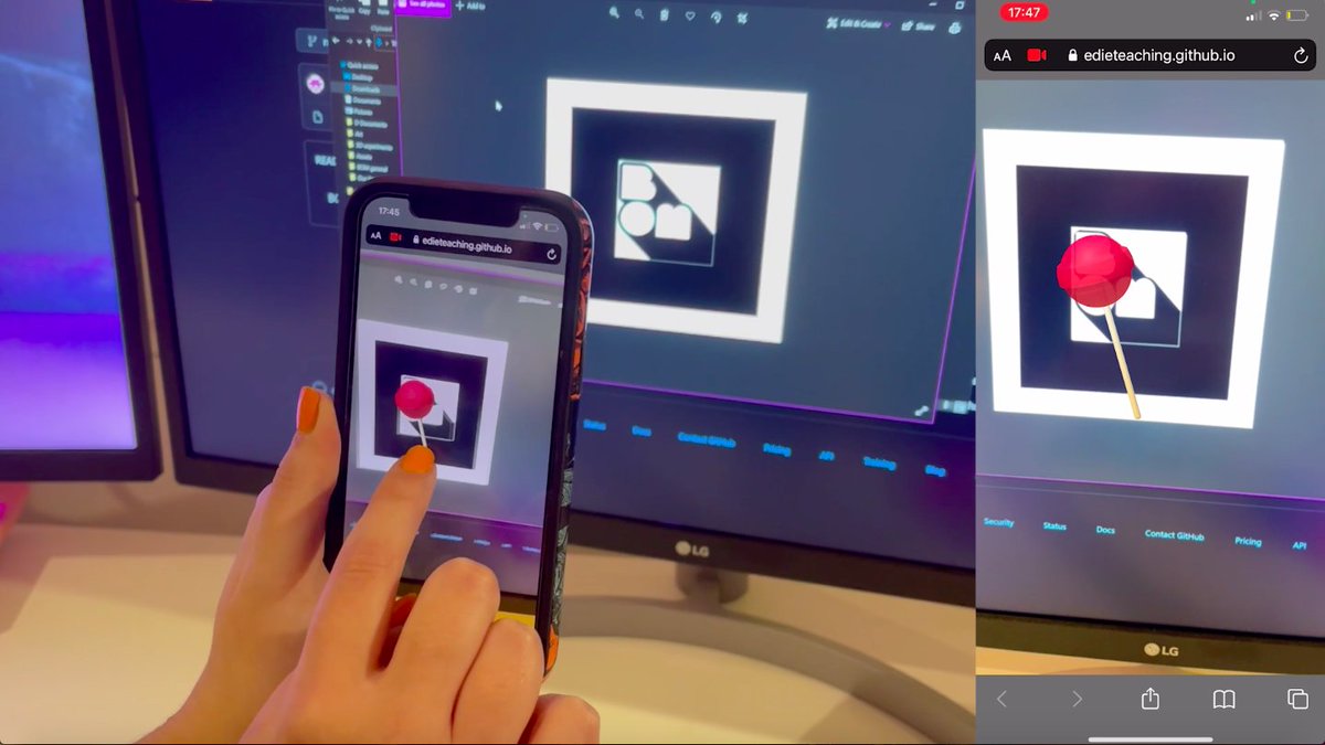 A photo of two hands holding a smart phone in front of a desktop computer. The same digital image is present on both devices. It looks like a lollipop in front of the BOM logo, but I could be wrong....