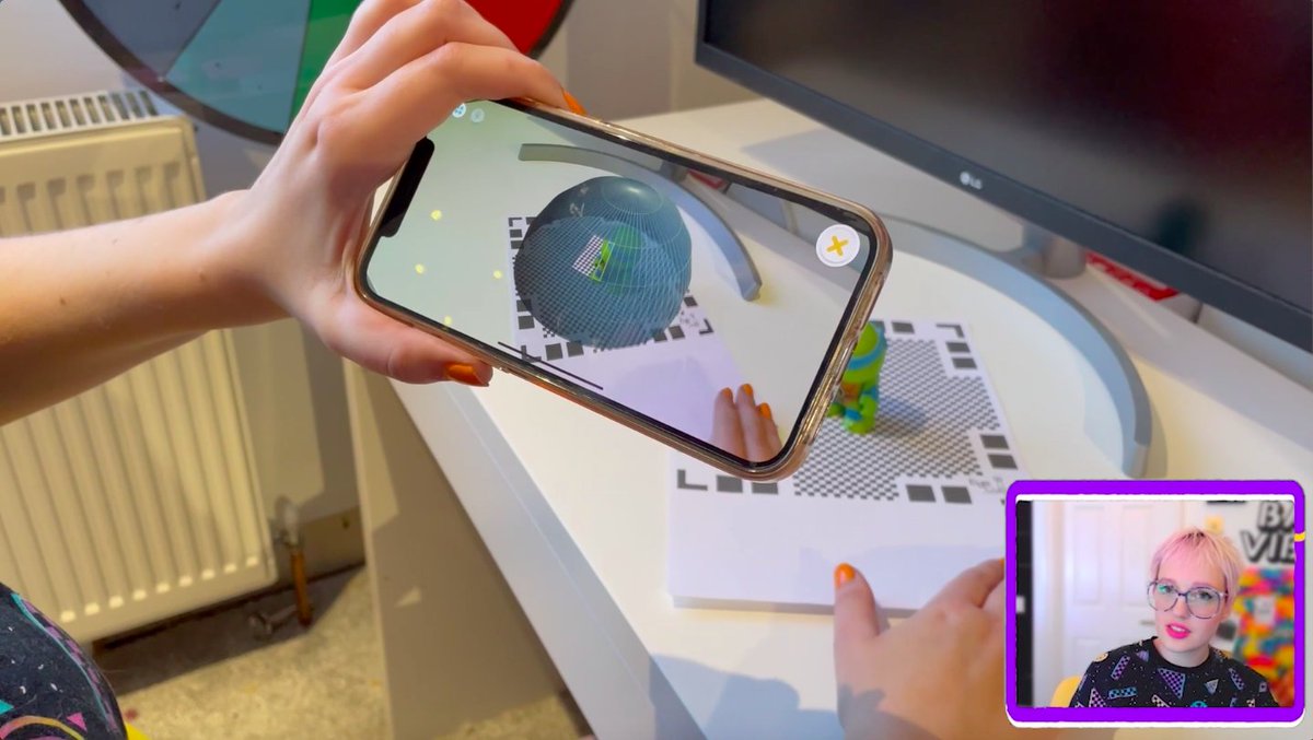 photo of a hand holding a smart phone with digital imagery, in the corner of the photo is a thumbnail pic of course leader Edie Jo Murray as she explains the process.