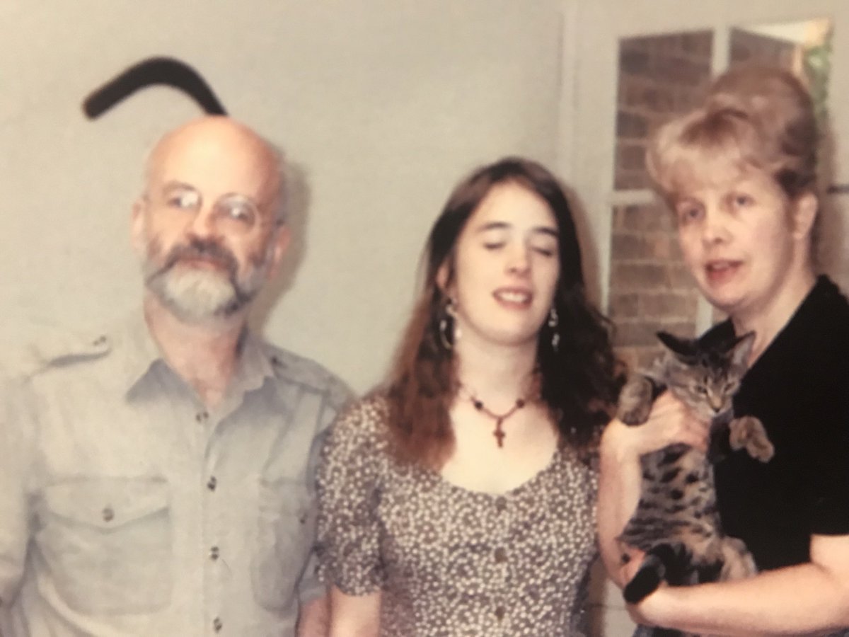 rhipratchett's tweet photo. This is in many ways a typical Pratchett photo - Mum is holding a cat, I’m trying to pretend it’s not happening and Dad has boomerang sticking out of his head.
Come back, Dad. The world needs you. 7 years is long enough. ❤️ ⁦@terryandrob⁩ #GNUTerryPratchett #SpeakHisName https://t.co/vv6PspfKtr