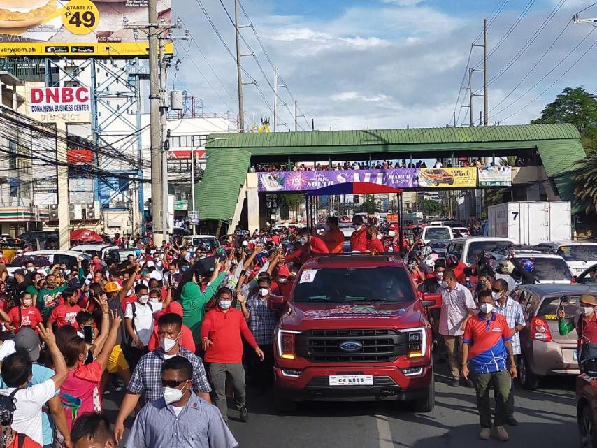 newswatchplusph's tweet photo. @RexRemitio Supporters patiently wait to welcome the UniTeam Alliance’s motorcade in Las Piñas City. Heavy traffic on both lanes of Alabang-Zapote Road as of 4:30pm. #TheFilipinoVotes | @RexRemitio https://t.co/4kSTFqSfyn