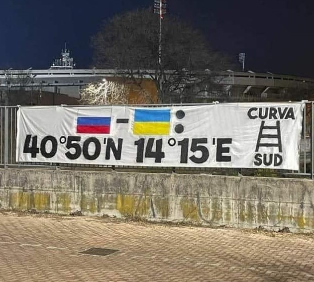 Ecco lo striscione "sofisticato"  in cui in modo "goliardico" (termine che viene utilizzato esclusivamente per definire il razzismo verso il popolo ed il territorio napoletano) i tifosi della curva sud del Verona inviano le coordinate di Napoli alla Russia ed all'Ucraina ...