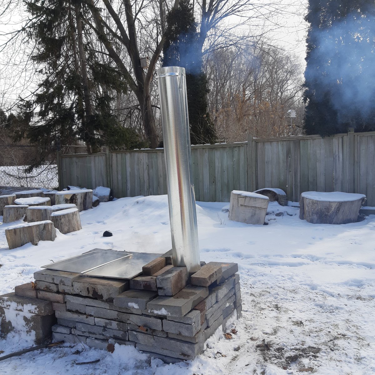 Built a little maple sap evaporator with some bricks, pans, and some duct material.   Boiling sap is a relaxing way to enjoy March weather! #maplesyrup #outdooreducation #canada