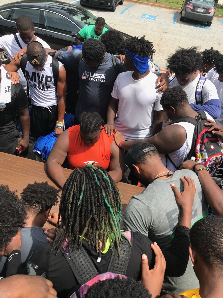 Columbia High School Football team praying over one of their teammates. These young men are carrying one another's burdens.